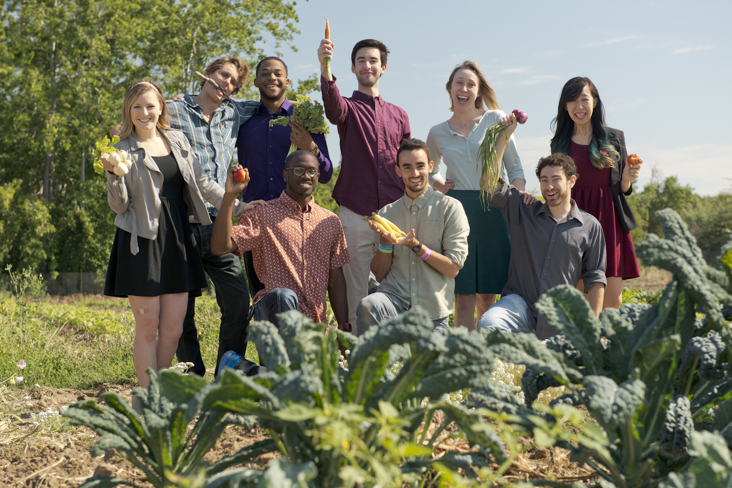 students in a field holding various produce
