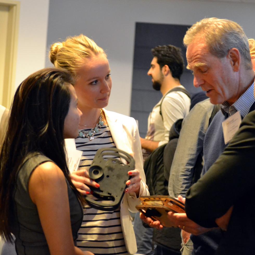 Rose Hong Truong (left) and Natalya Shelby discuss their innovation, the VisionFinder, with Professor Tu Jarvis, director of the Blum Center for Developing Economies at UC Davis. 