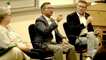 three professionals sitting in front of a classroom