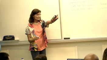 woman lecturing in front of a classroom