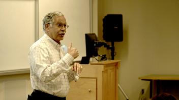 man standing and speaking in front of a classroom