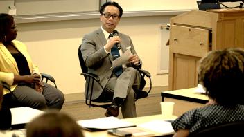 Man in business attire speaking at a conference.