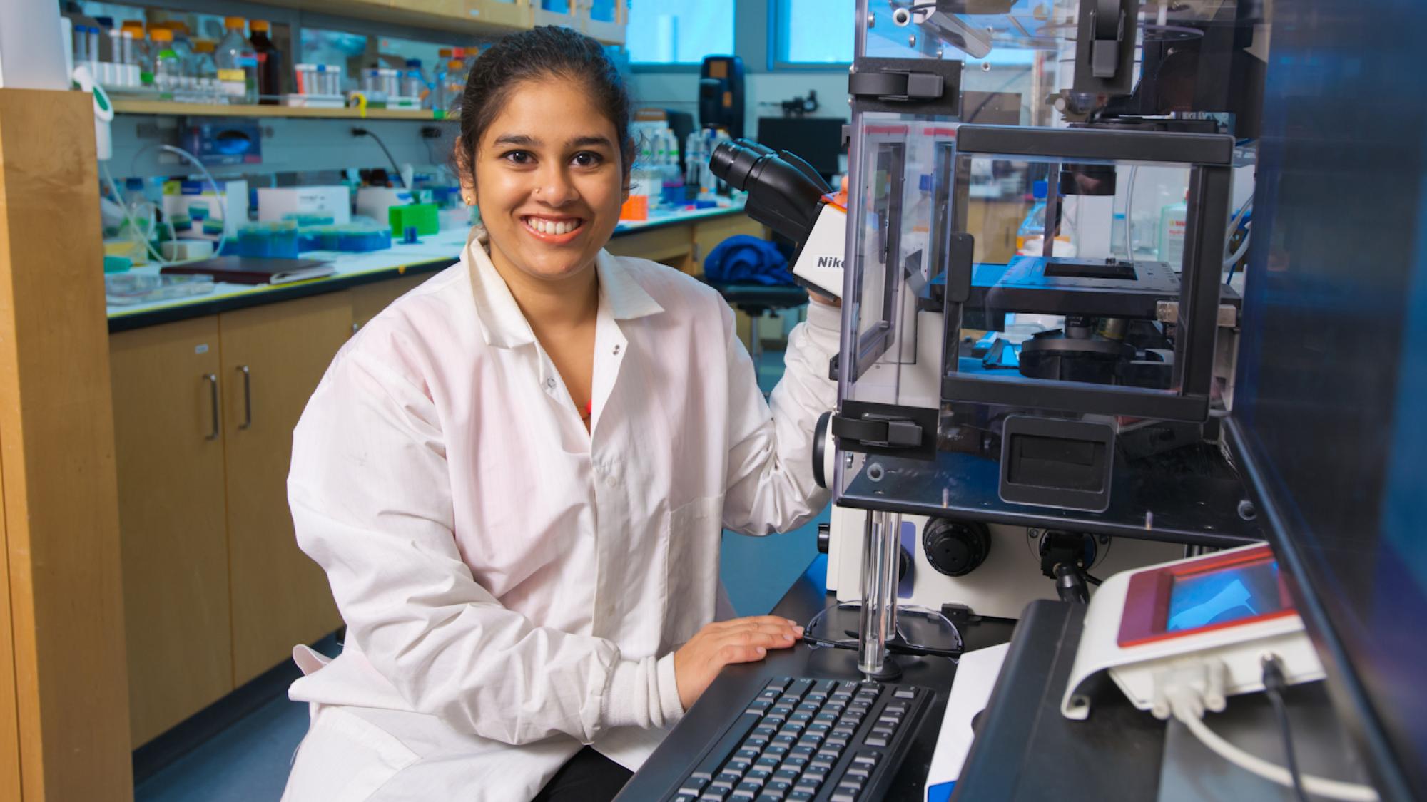 woman student in lab wearing lab coat