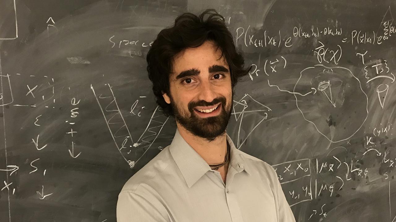 Fabio Anza Business Development Fellow standing in front of chalkboard with equations