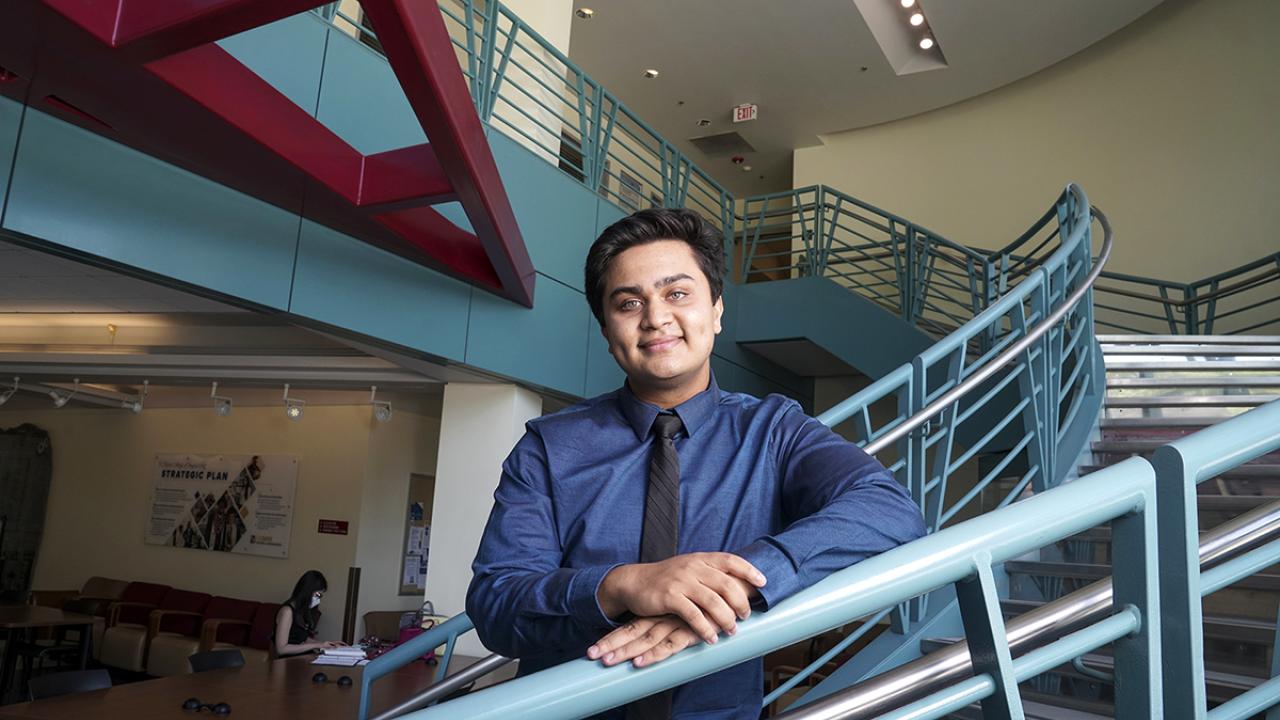 young man standing on a staircase in an academic building