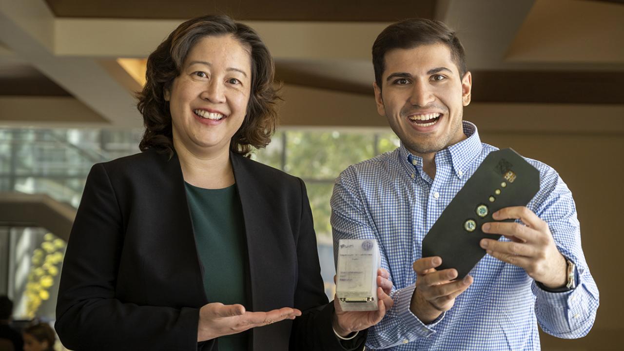 photo of two student entrepreneurs holding a prototype