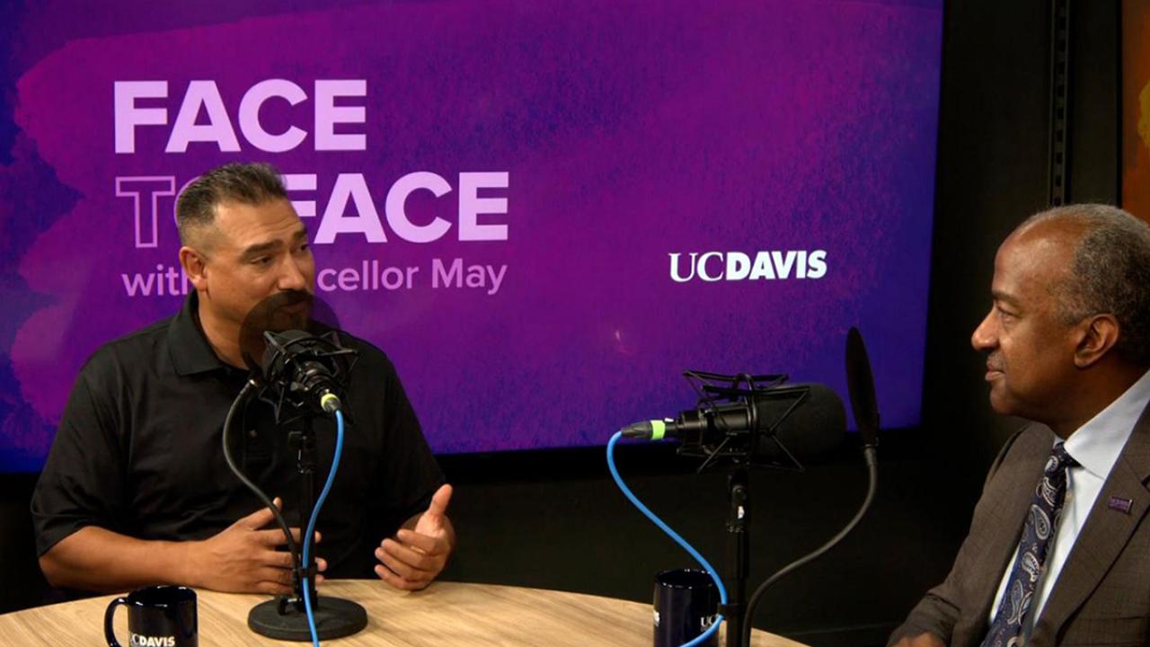 image of two people sitting and talking indoors with text 'Face to Face with Chancellor May UC Davis'