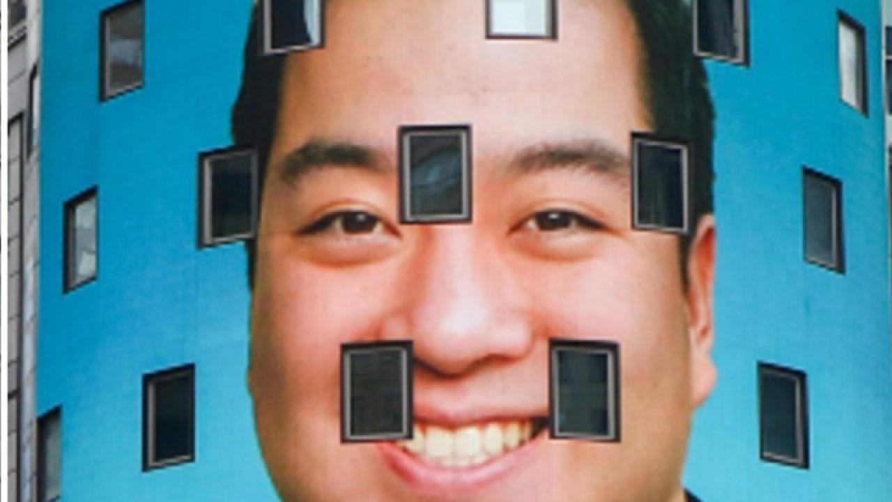 Ben Wang's headshot is projected on the NASDAQ building 