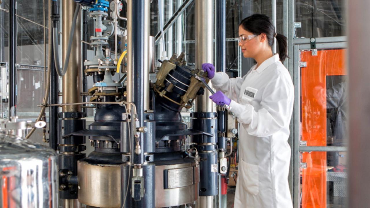 scientist in lab coat and ppe working on equipment at Origin Materials’ West Sacramento facility.