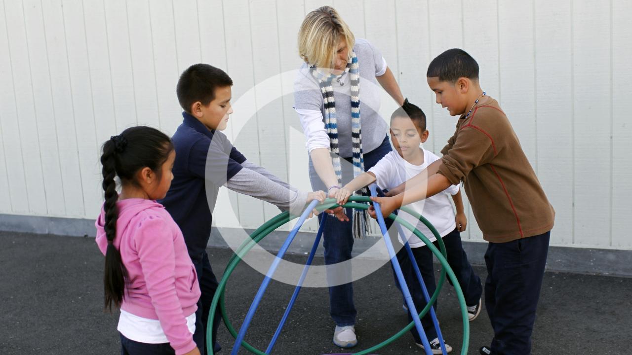 woman playing with children on playground
