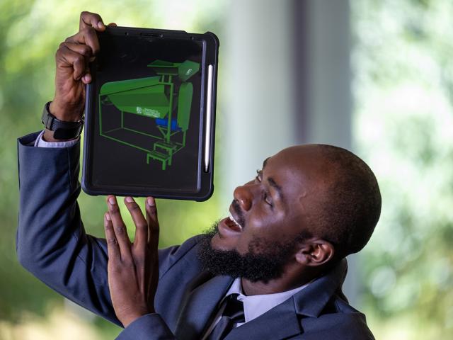 photo of a man holding an ipad opened to a website