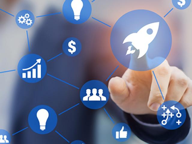 translucent screen with various startup icons; behind it is a man pointing at them