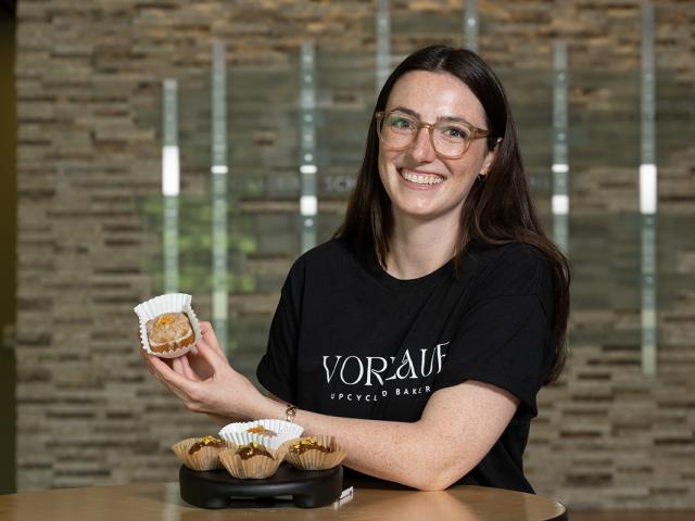 photo of a woman holding up baked goods