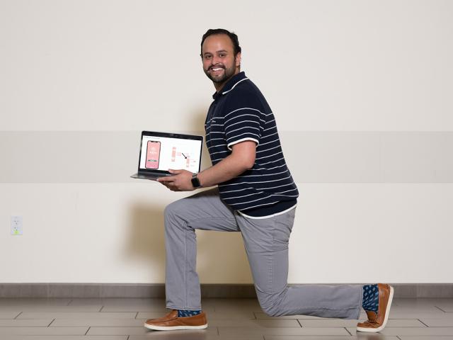 photo of a man doing a lunge and holding laptop opened to his physical therapy app