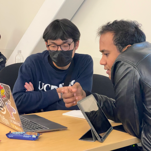 two undergraduate students talking in a classroom