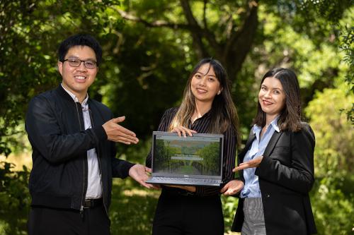photo of three people standing outdoors with a laptop open to an image of winegrapes