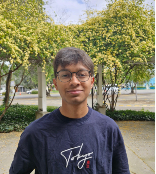 Photo of student standing in front of trees