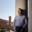 male grad student standing by academic building