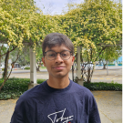 Photo of student standing in front of trees