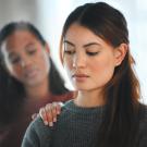 photo of two women, one comforting the other