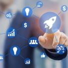 translucent screen with various startup icons; behind it is a man pointing at them
