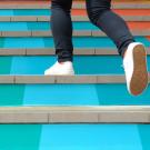 legs and feet of someone running up a colorful staircase
