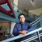 young man standing on a staircase in an academic building