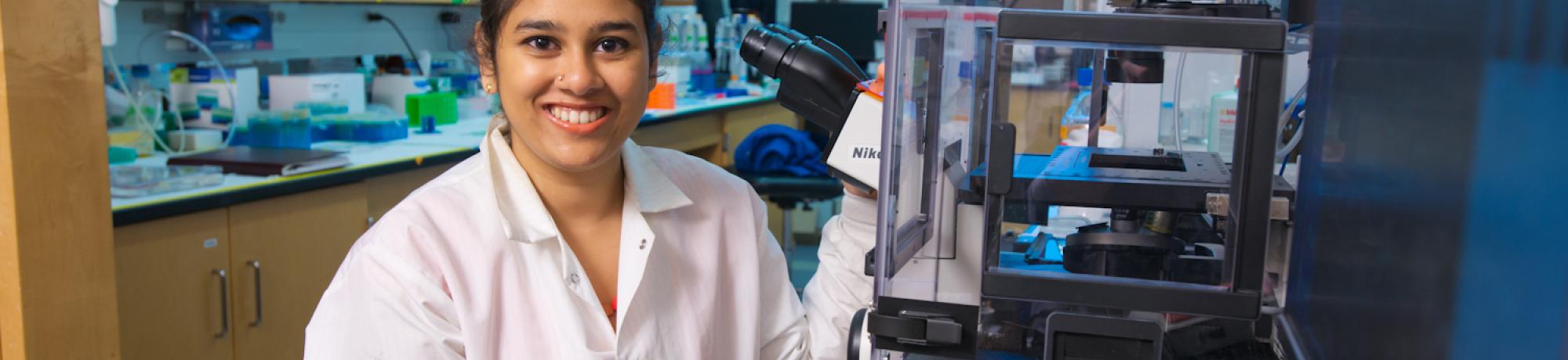 woman student in lab wearing lab coat